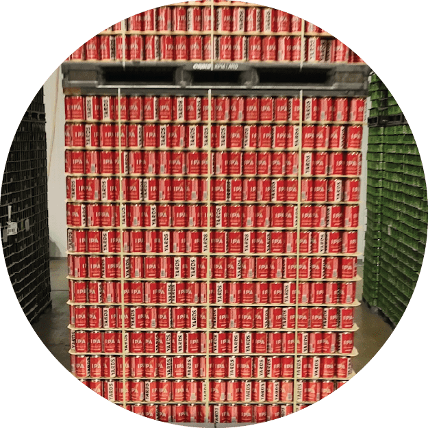 Large stack of red soda cans in warehouse