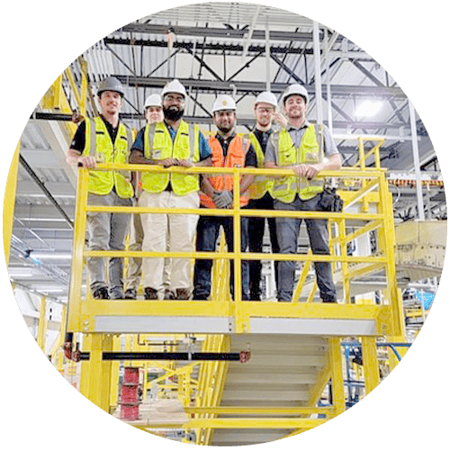 ProAutomated engineer teem meeting: group of men in hard hats and bright vests on yellow stair landing,